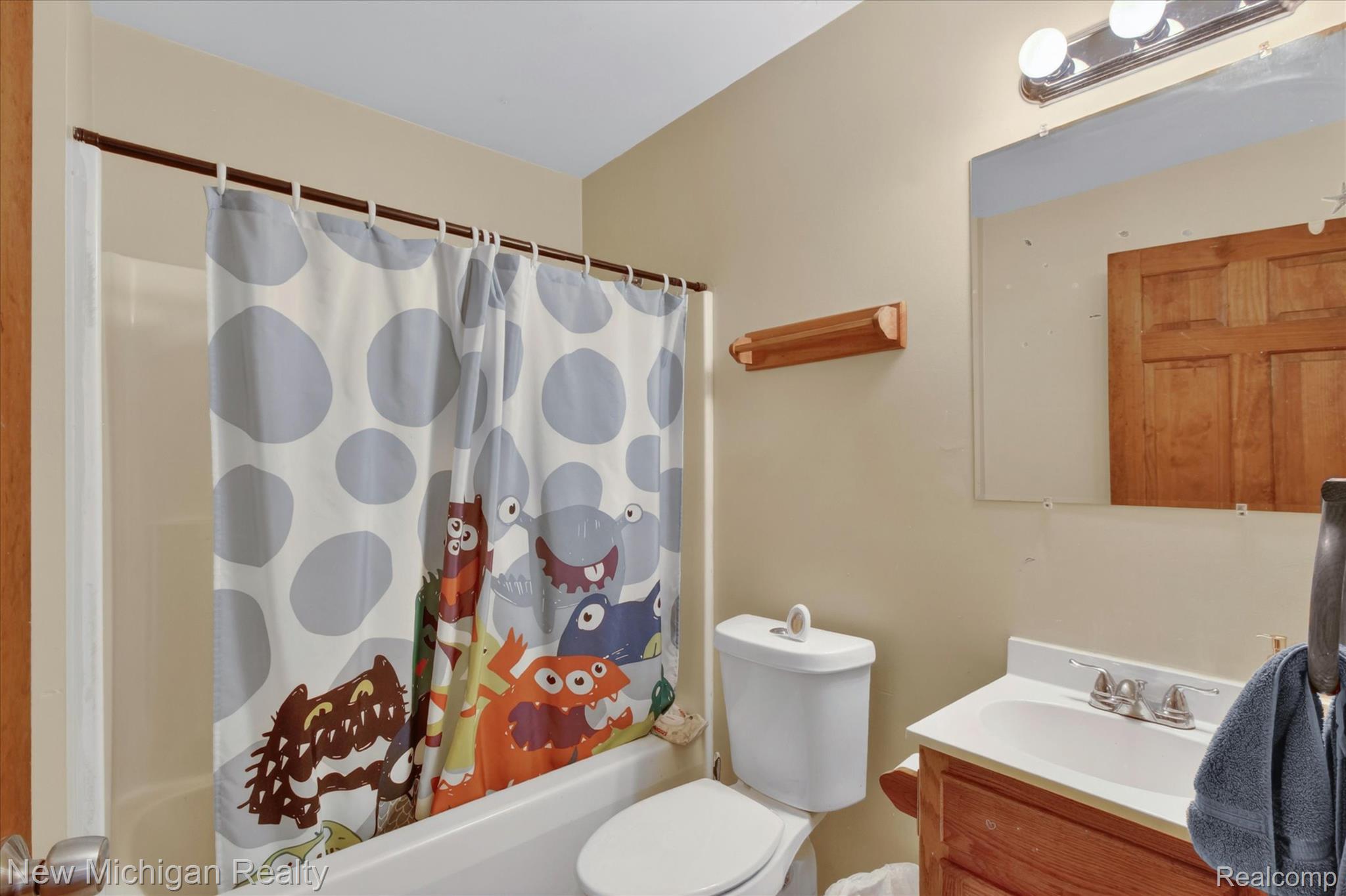 22623 11 Mile Road Reed City, MI 49677 - Photo 26 of 47 Full bathroom featuring a white tub, toilet, and a vanity with a white countertop and chrome faucet