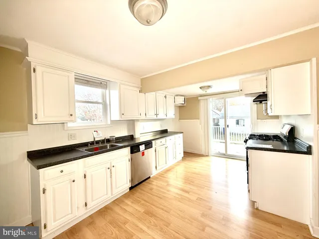 a large kitchen with granite countertop a sink and a stove top oven