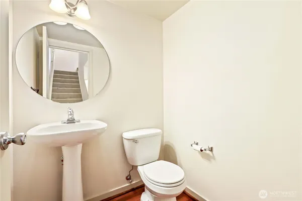 a bathroom with a toilet a sink and mirror