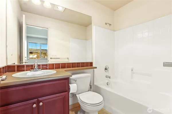 a bathroom with a toilet a sink a mirror a bathtub and shower