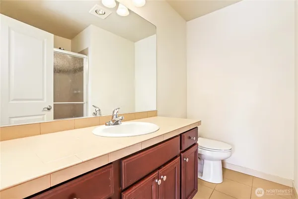 a bathroom with a sink a toilet and a mirror