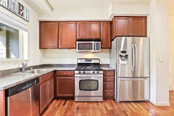a kitchen with a stove refrigerator and microwave