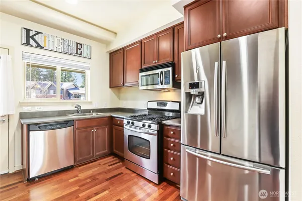a kitchen with stainless steel appliances granite countertop a refrigerator stove and sink