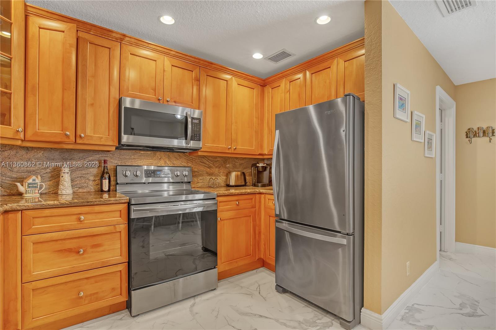 119 Ocean Dunes Circle Jupiter, FL 33477 - Photo 12 of 39 a kitchen with stainless steel appliances granite countertop a refrigerator stove and microwave