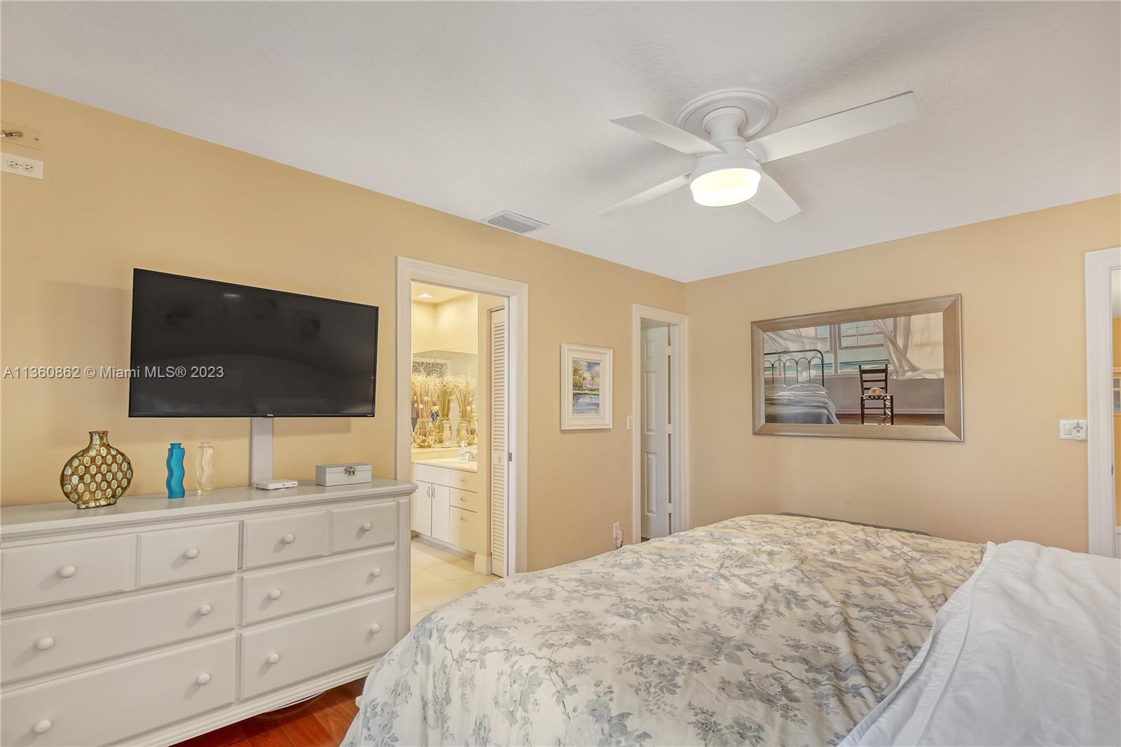 119 Ocean Dunes Circle Jupiter, FL 33477 - Photo 27 of 39 a bedroom with a bed and a flat screen tv