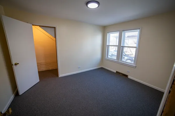 an empty room with windows and closet