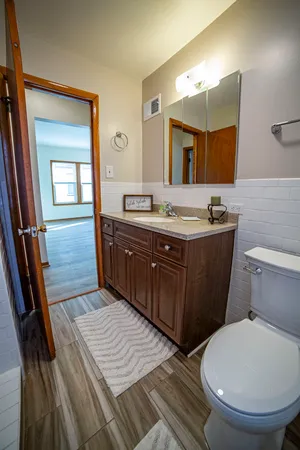 a bathroom with a granite countertop toilet sink and mirror