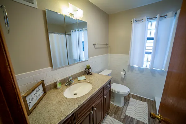 a bathroom with a granite countertop sink toilet and shower a mirror