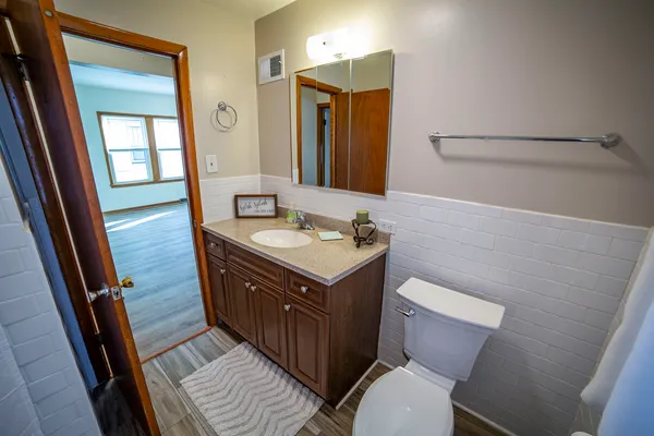 a bathroom with a sink vanity mirror and toilet