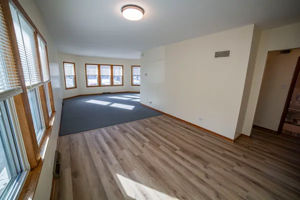 a view of wooden floor and windows in a room