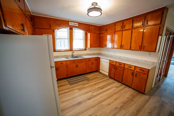 a view of a kitchen with wooden floor and a sink