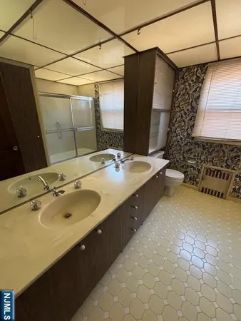 a bathroom with a double vanity sink and mirror