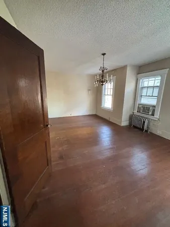 an empty room with staircase and windows