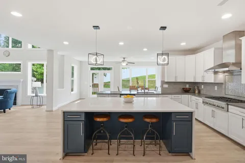 a large kitchen with granite countertop a stove a sink a table and chairs