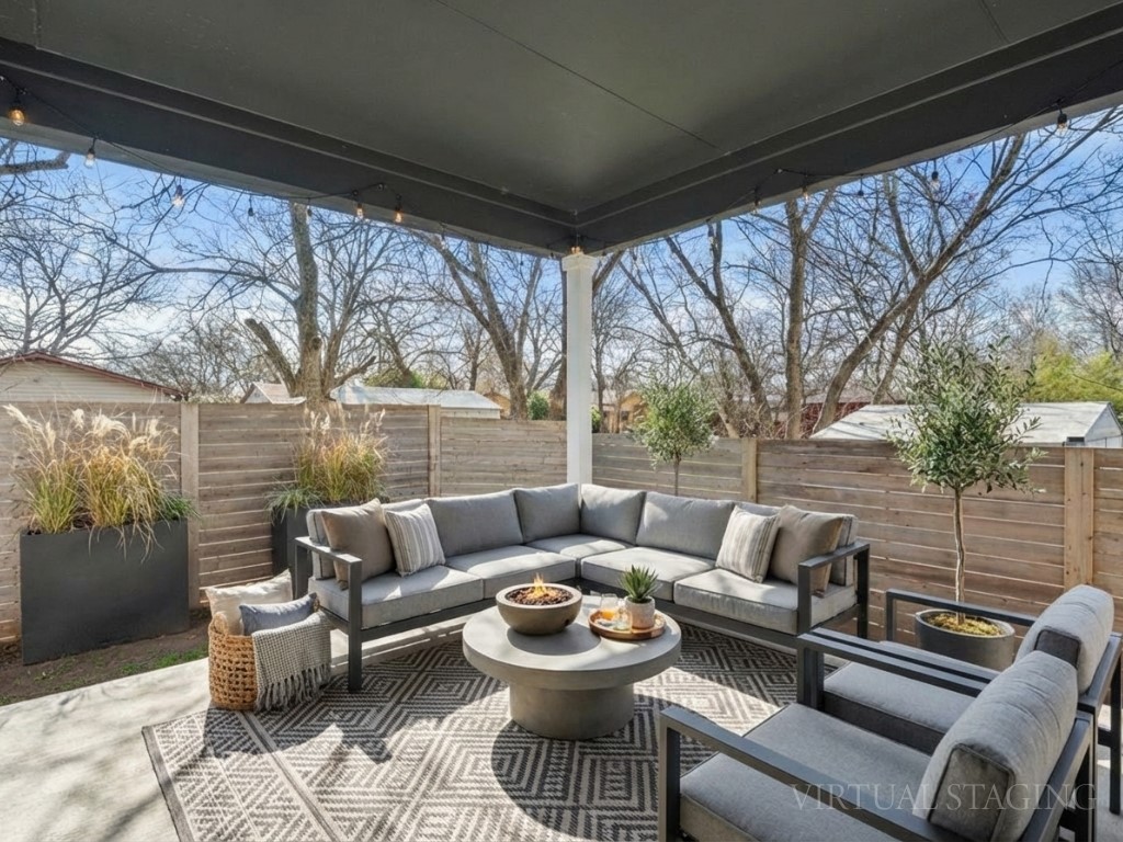 Fenced backyard with a patio area and an outdoor living space with a fire pit