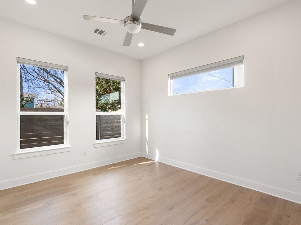 709 West St Elmo Road, Unit 2 Austin, TX 78745 - Photo 14 of 26 Empty room featuring light wood finished floors, plenty of natural light, a ceiling fan, and recessed lighting