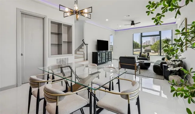 a living room with furniture a chandelier and a flat screen tv