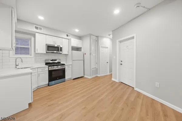 a kitchen with kitchen island a sink stainless steel appliances and cabinets