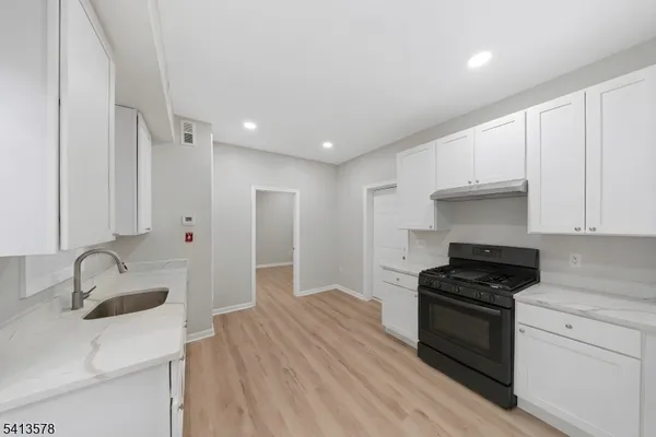 a kitchen with granite countertop a sink stainless steel appliances and cabinets