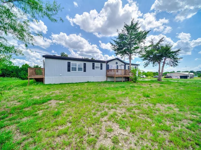 a view of a house with a yard and sitting area