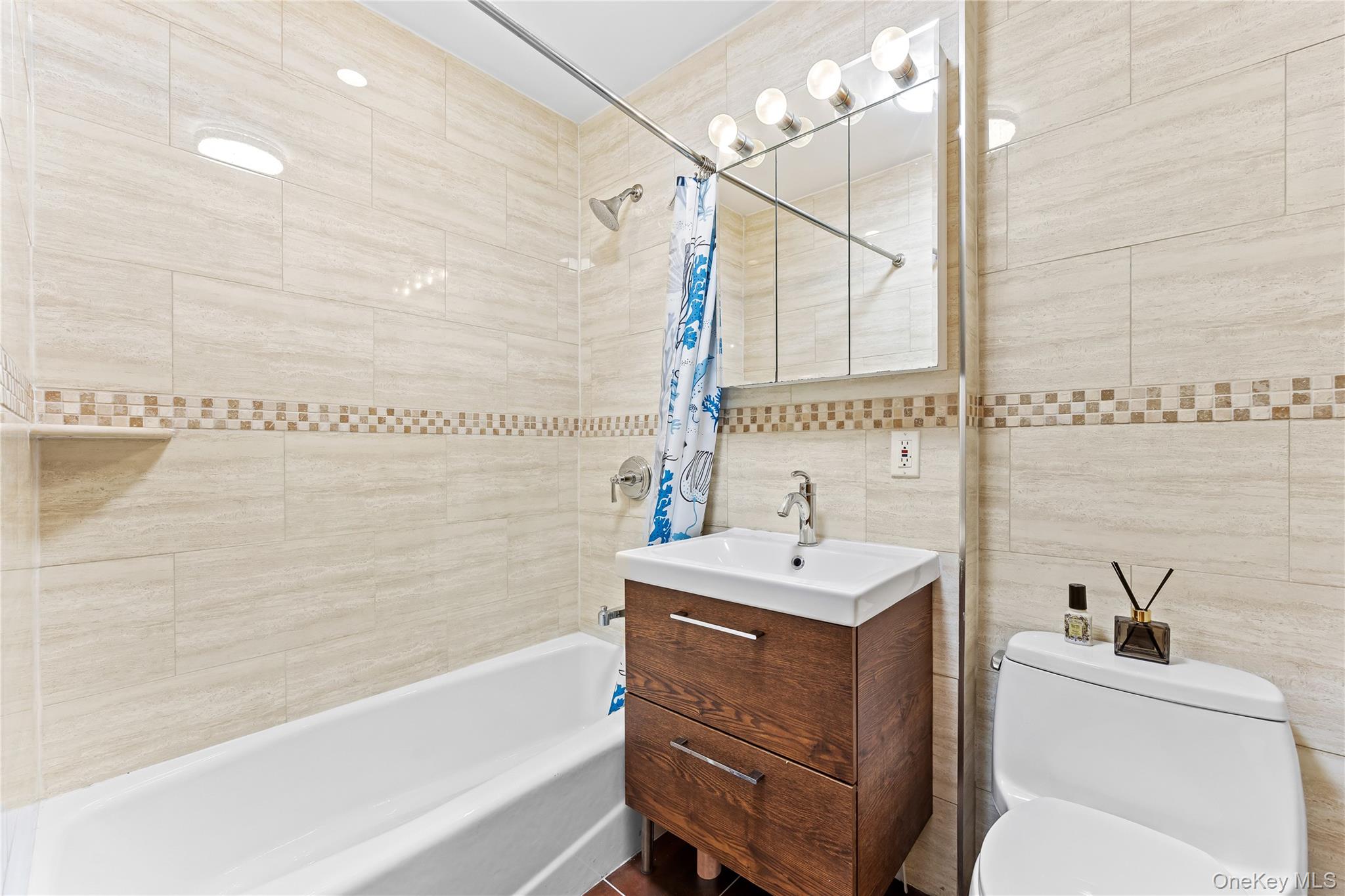 95-08 65th Road, Unit 3C Queens, NY 11374 - Photo 13 of 19 Bathroom featuring shower / bathtub combination with curtain, tile walls, and vanity