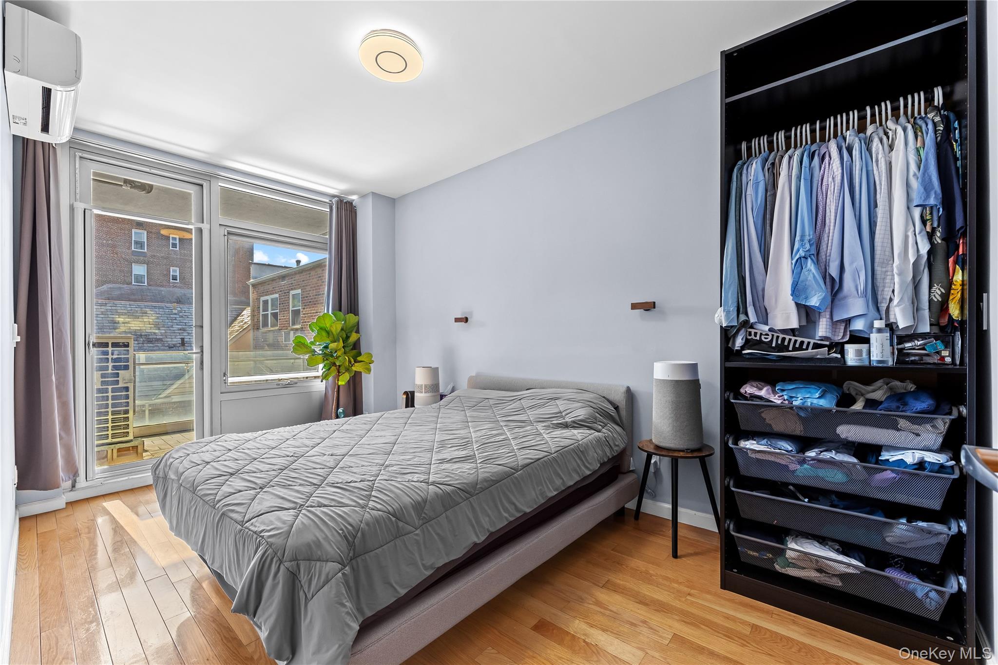 95-08 65th Road, Unit 3C Queens, NY 11374 - Photo 10 of 19 Bedroom with light wood-style flooring and a wall mounted AC