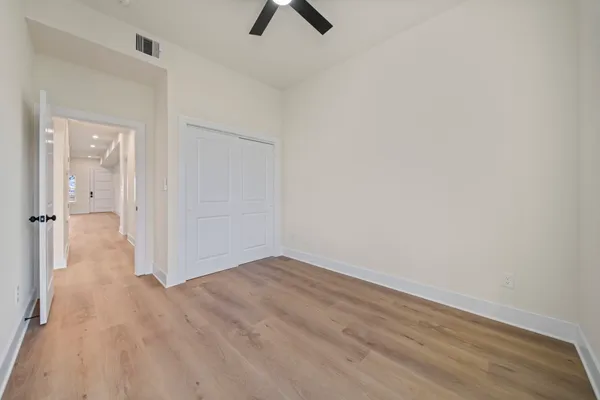 an empty room with a ceiling fan and carpet