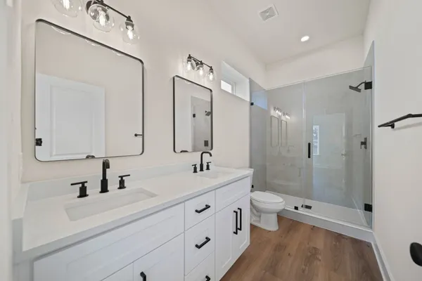 a bathroom with a toilet a sink a mirror and a bathtub