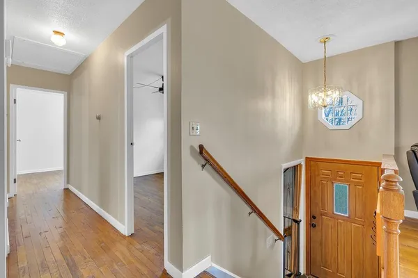 a view of a hallway with wooden floor and stairs