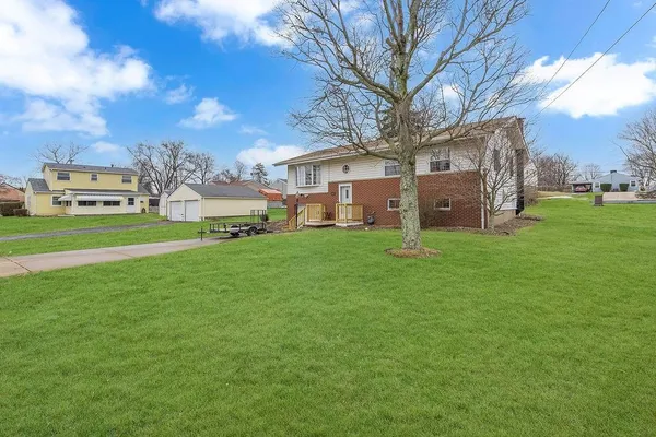 a view of a house with a big yard and large trees