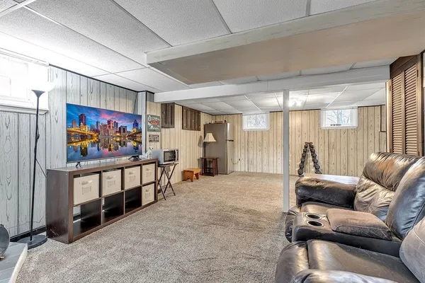 a living room with furniture a wall paintings and a projector