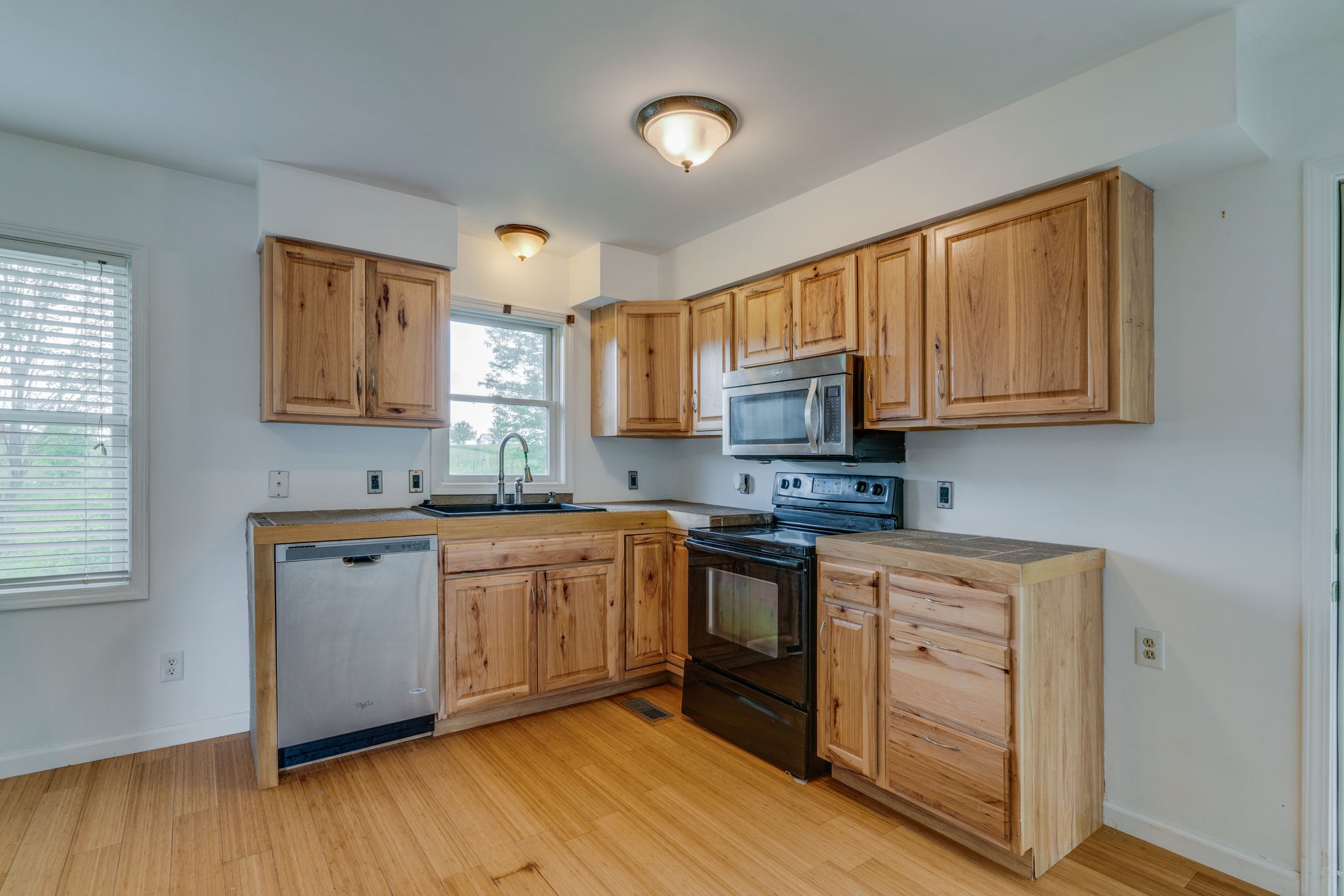4614 Woodrow Wilson Road Springfield, TN 37172 - Photo 10 of 29 a kitchen with stainless steel appliances granite countertop wooden cabinets a stove a sink and dishwasher with wooden floor