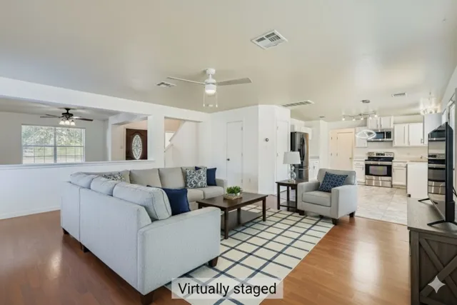 a living room with furniture and a wooden floor