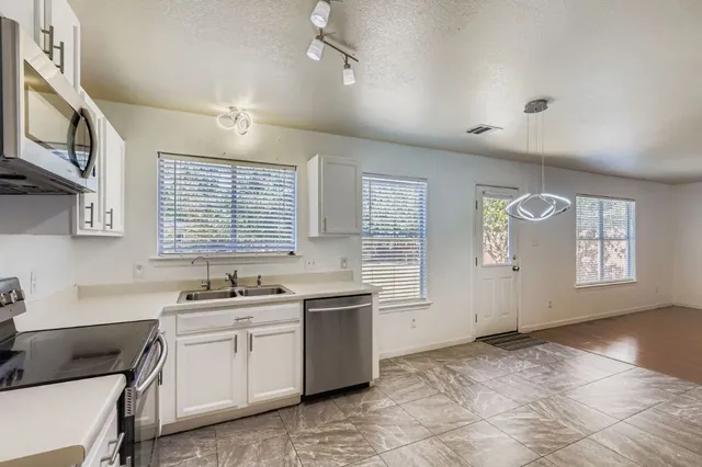 a kitchen with a sink stove and cabinets