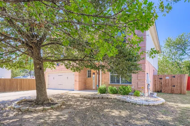 a front view of a house with a yard and tree
