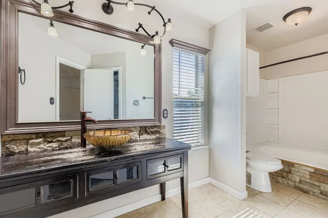 a bathroom with a sink a toilet and a mirror