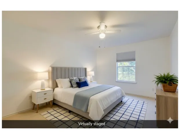 a bedroom with a large bed and a chandelier