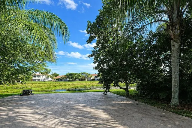 a view of a lake with a big yard and large trees