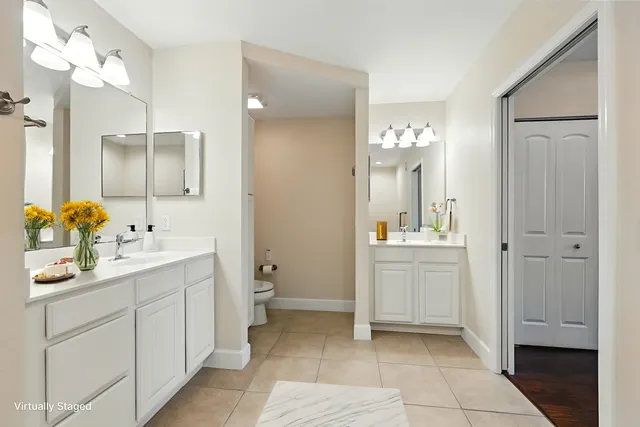 a en suite bathroom with a double vanity sink a large mirror and a shower