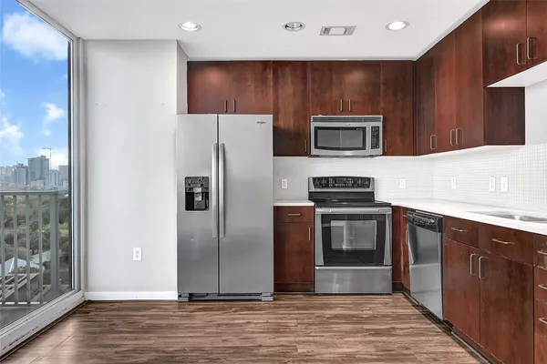 a kitchen with stainless steel appliances kitchen island granite countertop a refrigerator and a stove