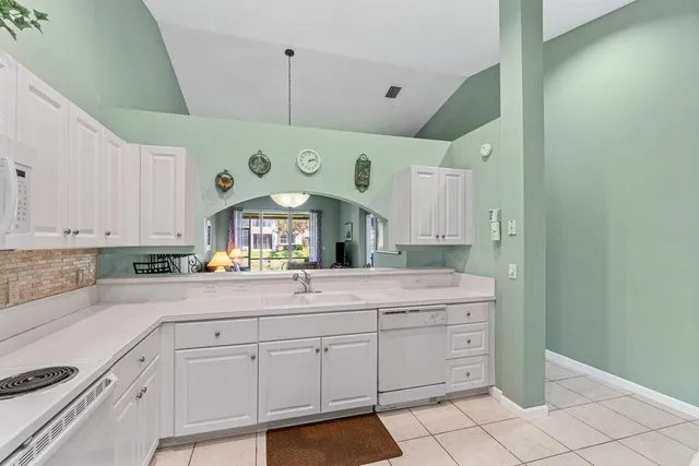 a kitchen with a white cabinets and chandelier