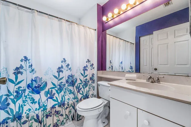a bathroom with a sink mirror vanity and toilet