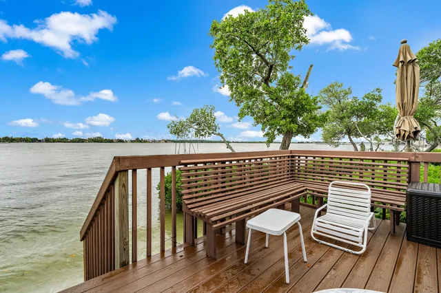 a view of a balcony with wooden floor and iron fence