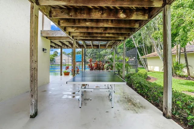 a view of patio with a table and chairs under an umbrella
