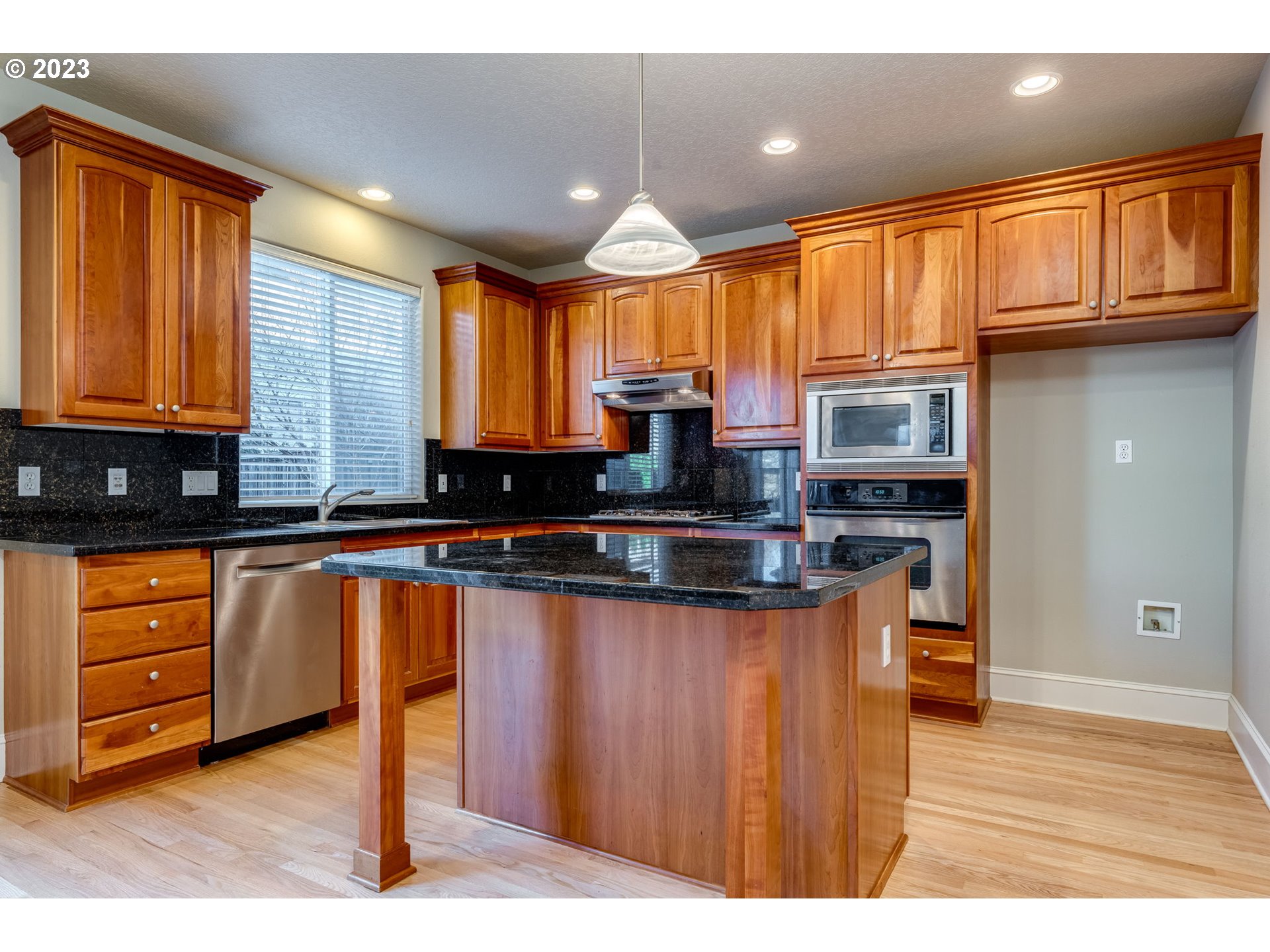 12581 Northwest Forest Spring Lane Portland, OR 97229 - Photo 18 of 48 a kitchen with stainless steel appliances granite countertop wooden cabinets a refrigerator a sink a stove and wooden cabinets