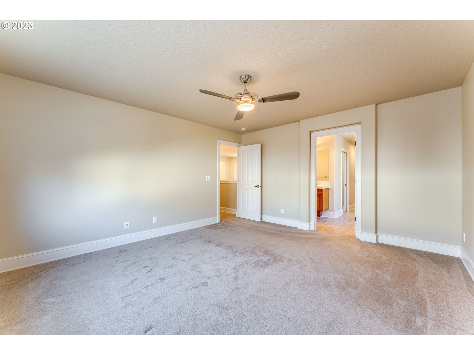 12581 Northwest Forest Spring Lane Portland, OR 97229 - Photo 35 of 48 a view of an empty room with a ceiling fan and a window
