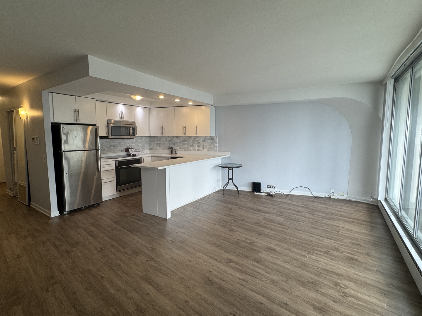 300 North State Street, Unit 4725 Chicago, IL 60654 - Photo 3 of 19 a kitchen with stainless steel appliances granite countertop a refrigerator a stove a sink and white cabinets with wooden floor