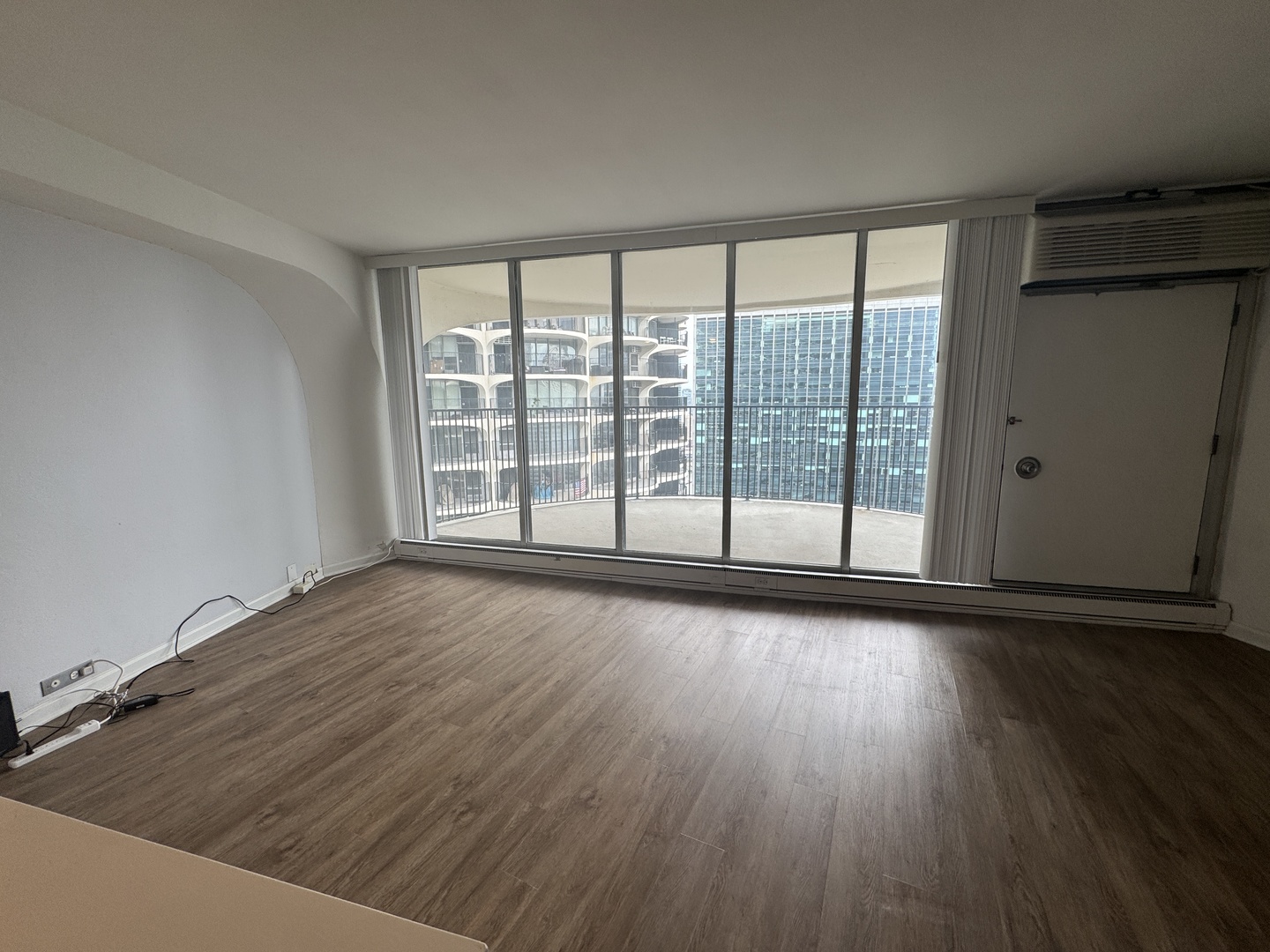 300 North State Street, Unit 4725 Chicago, IL 60654 - Photo 4 of 19 wooden floor in an empty room with a window