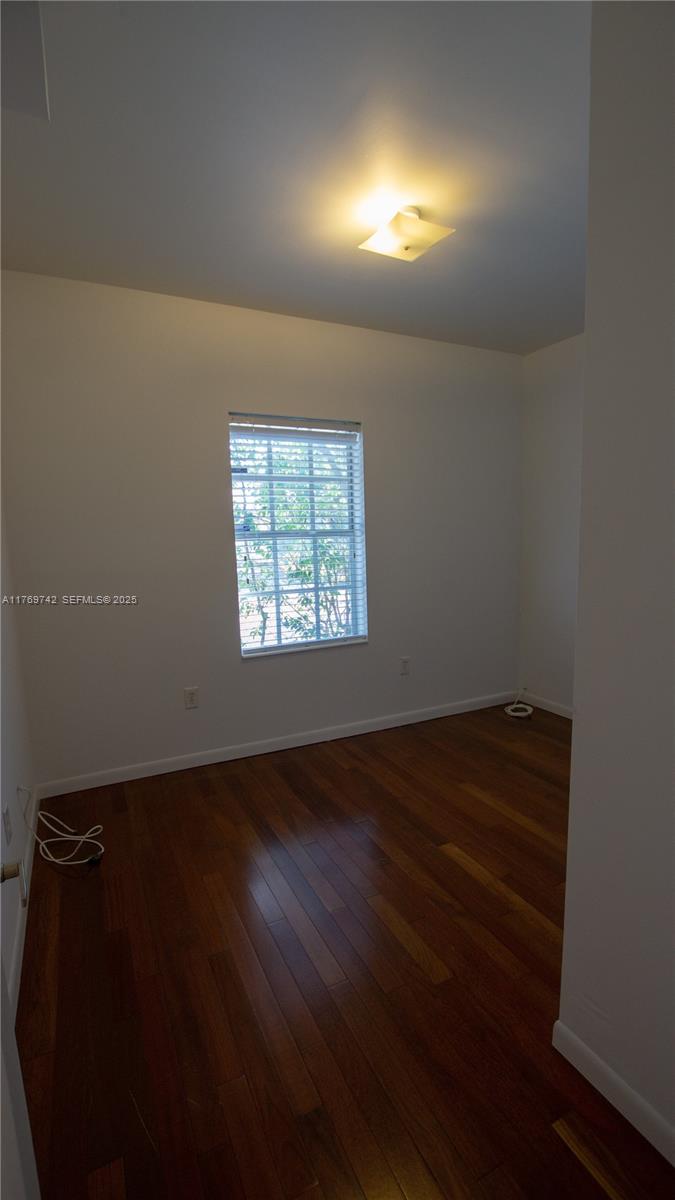 577 Northeast 62nd Street, Unit 2 Miami, FL 33138 - Photo 11 of 21 an empty room with wooden floor and windows