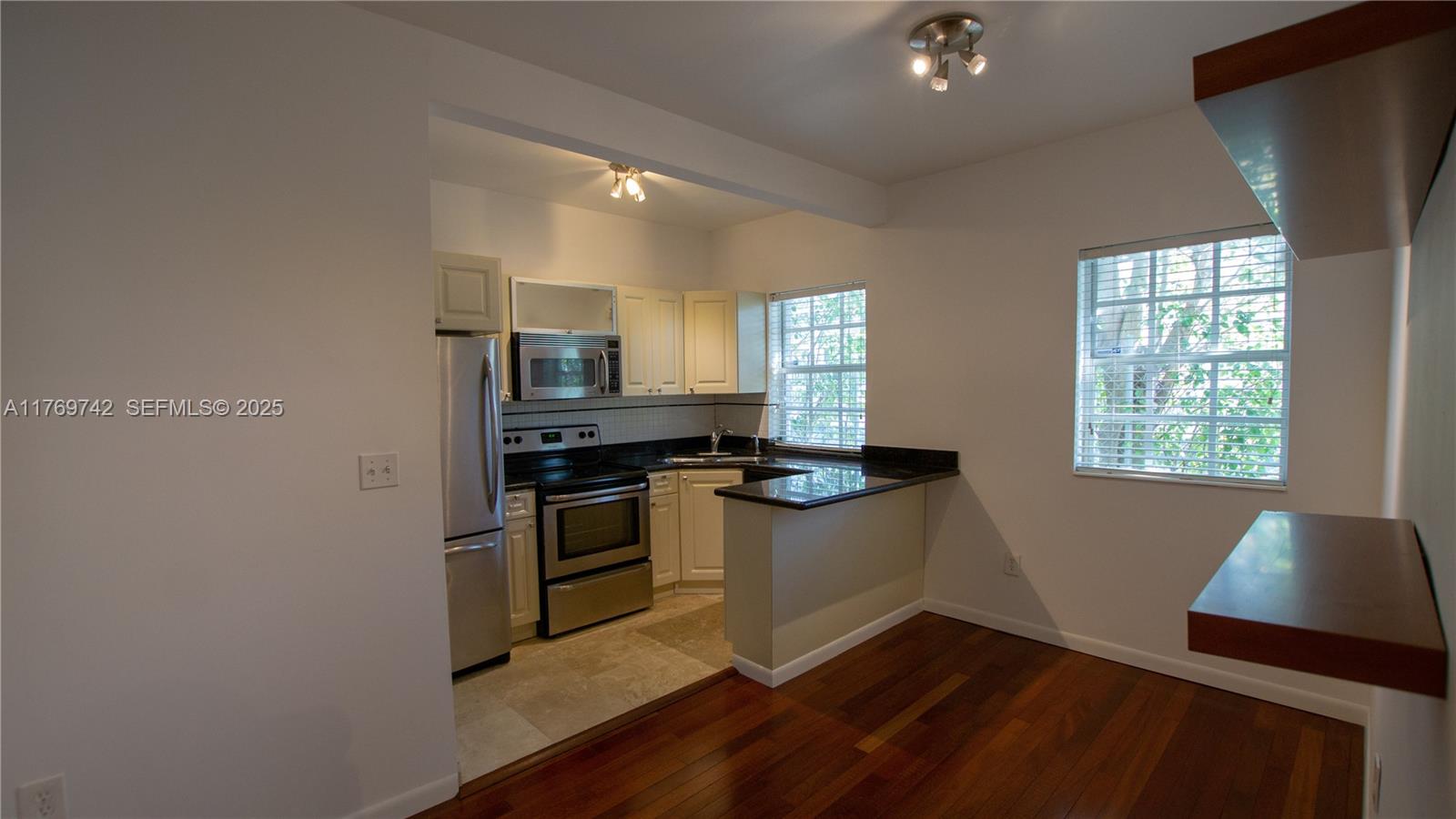 577 Northeast 62nd Street, Unit 2 Miami, FL 33138 - Photo 20 of 21 a kitchen with stainless steel appliances granite countertop a stove a sink and a refrigerator